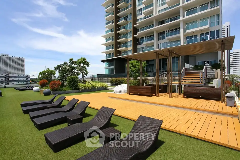 Luxurious rooftop garden with sun loungers and modern apartment building view