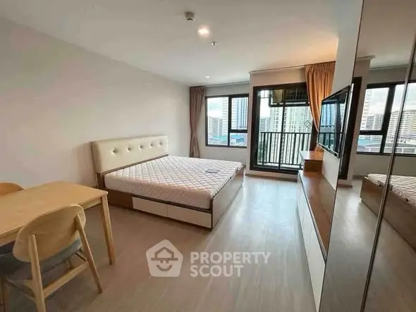 Modern bedroom with city view, featuring a cozy bed, wooden furniture, and large windows for natural light.