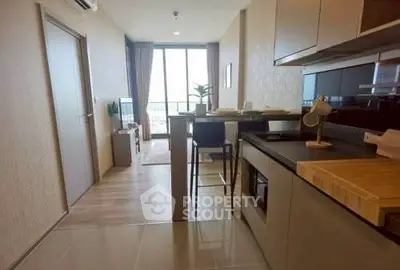 Modern open-layout kitchen with sleek appliances and a view into a stylish living area.