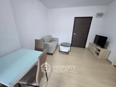 Modern living room with minimalist furniture and sleek design, featuring a cozy sofa and entertainment unit.