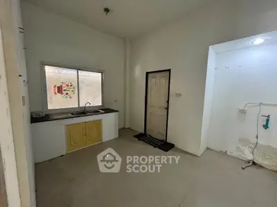 Spacious kitchen area with simple design and ample natural light, perfect for customization.