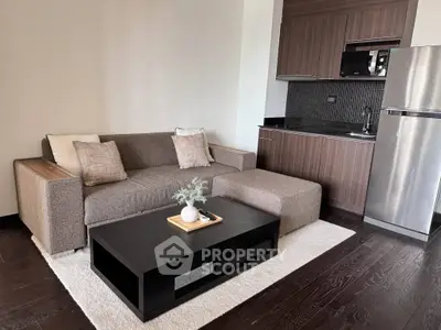 Modern living room with sleek kitchenette and stylish furniture in a cozy apartment setting.