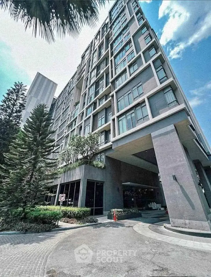 Modern high-rise building with sleek architecture and lush landscaping.