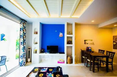 Modern living room with vibrant blue accent wall and stylish dining area