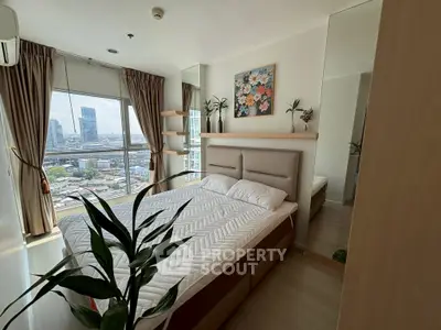 Modern bedroom with city view, featuring elegant decor and large windows for natural light.