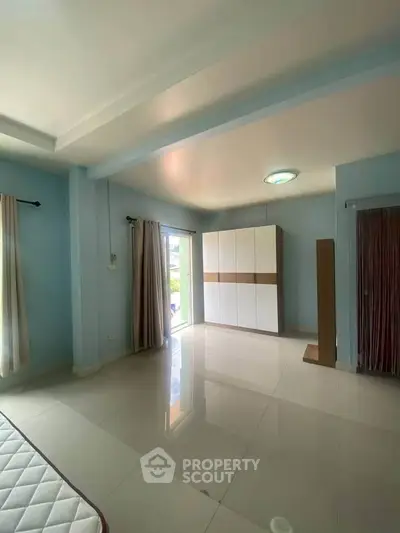 Spacious bedroom with large windows and modern wardrobe, perfect for natural light lovers.