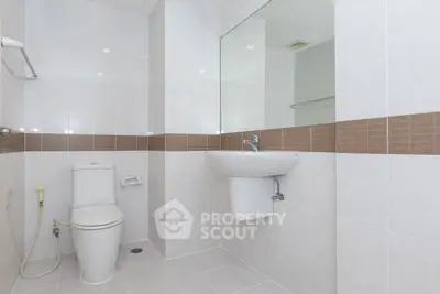 Modern bathroom with sleek white fixtures and tiled walls.