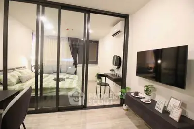 Modern bedroom with glass partition, stylish decor, and wall-mounted TV in a cozy apartment.