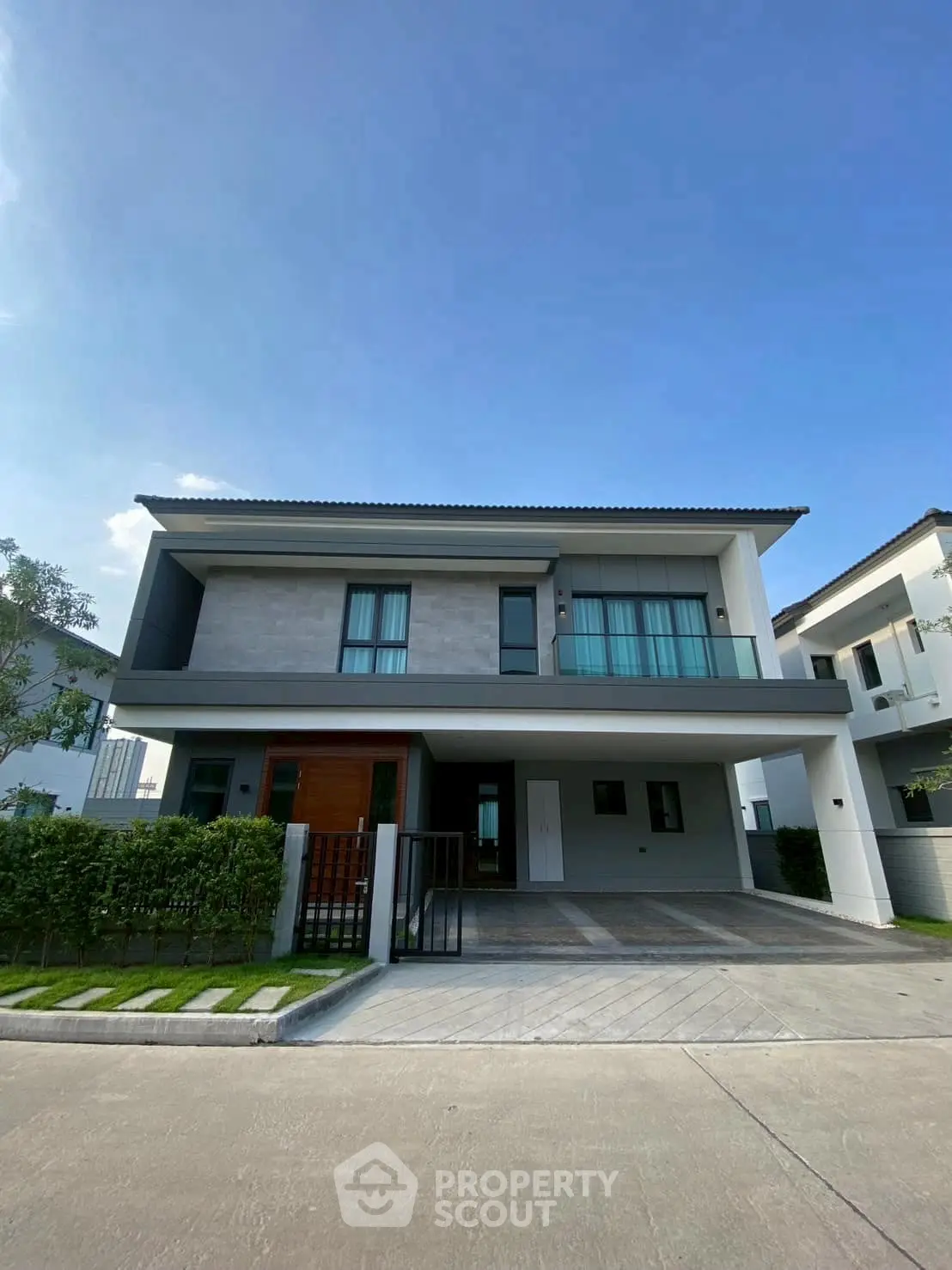 Modern two-story house with sleek design and spacious driveway in a serene neighborhood.