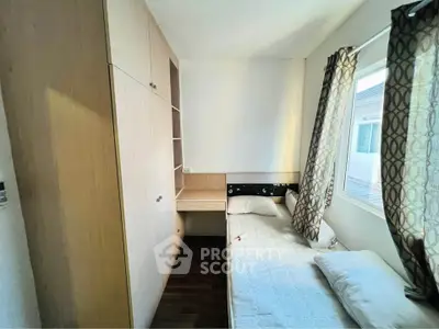 Cozy bedroom with built-in wardrobe and large window for natural light