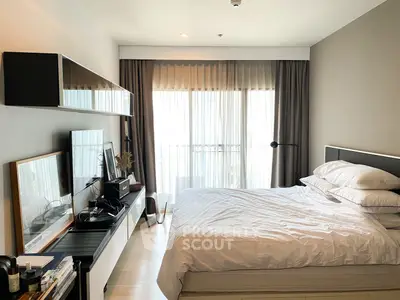 Modern bedroom with large window and stylish decor in a contemporary apartment.