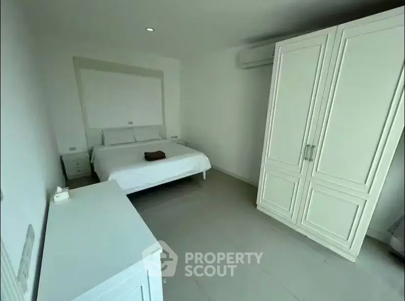 Spacious bedroom with white furniture and modern design