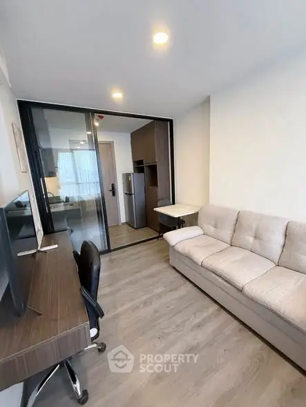 Modern living room with sliding glass doors and sleek furniture in a contemporary apartment.