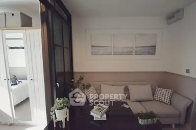 Charming living room with cozy sofa and modern decor, adjacent to a bright bedroom.