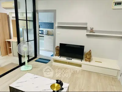 Modern living room with sleek design and open kitchen view, featuring stylish decor and ample natural light.