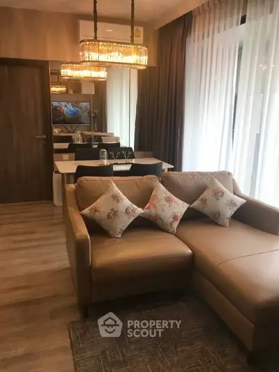 Elegant living room with cozy leather sofa and chic chandelier, perfect for modern urban living.