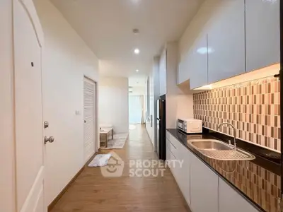 Modern kitchen with sleek cabinetry and stylish backsplash in a cozy apartment