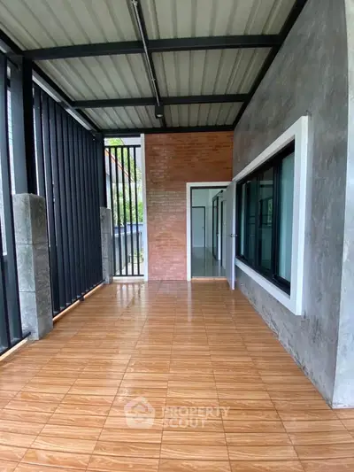 Spacious covered balcony with modern design and tiled flooring, perfect for relaxation.
