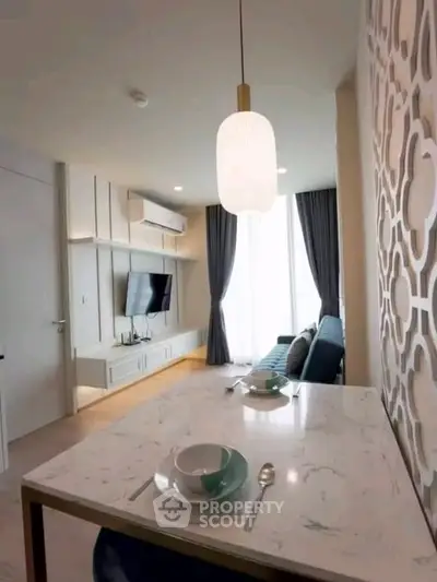 Modern living room with stylish decor and open layout, featuring a cozy seating area and elegant lighting.