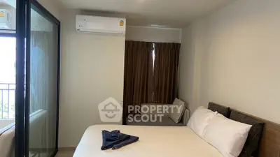 Cozy bedroom with modern air conditioning and balcony access, perfect for urban living.