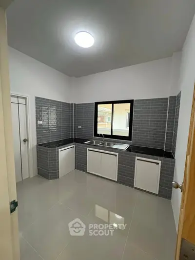 Modern kitchen with sleek gray tile backsplash and ample counter space