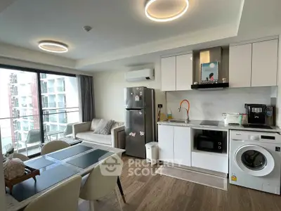 Modern open-plan kitchen and living area with balcony access in a stylish apartment.