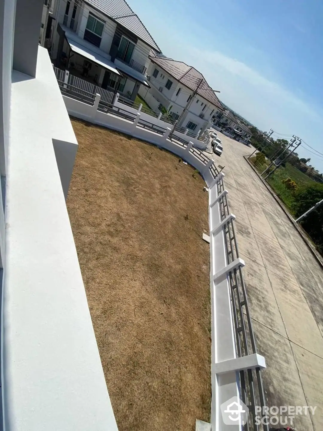 Spacious sunlit balcony with a panoramic suburban view, offering potential for outdoor living space or garden in a serene neighborhood.