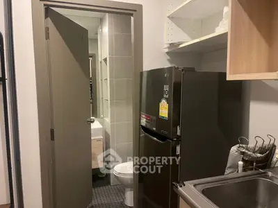 Compact kitchen with stainless steel sink and adjacent bathroom