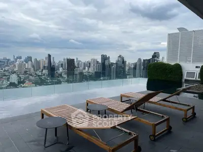 Luxurious rooftop pool with stunning city skyline view and modern lounge chairs.