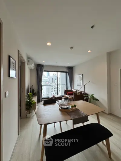 Modern living room with dining area and city view balcony in stylish apartment.