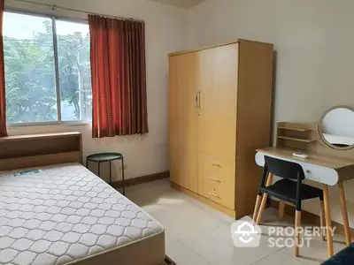 Cozy bedroom with ample natural light, featuring a large bed, wardrobe, and study area, perfect for relaxation and productivity.