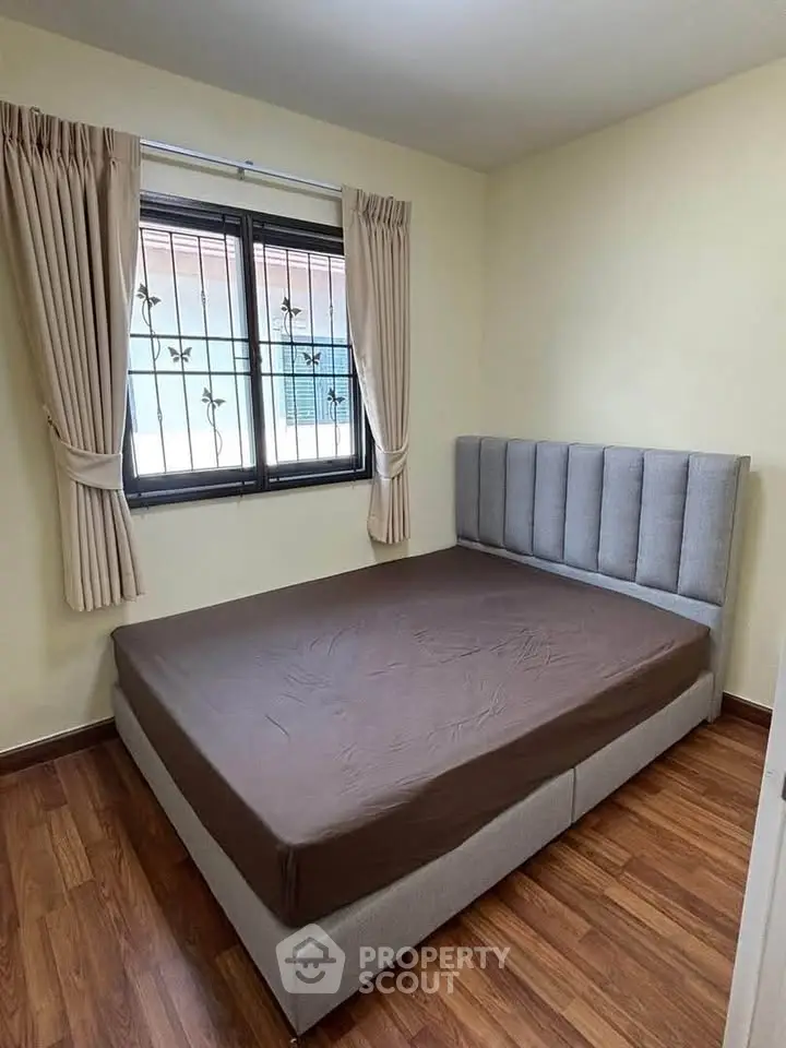 Cozy bedroom with modern bed and wooden flooring, perfect for restful nights.