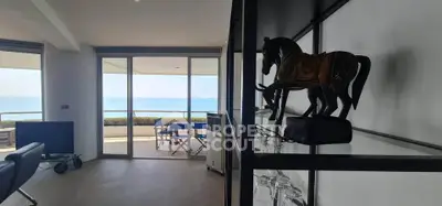 Stunning ocean view from modern living room with large balcony and elegant decor.
