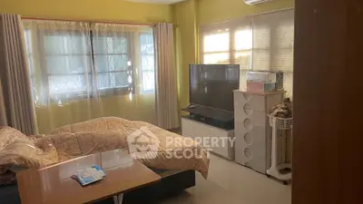 Cozy bedroom with large windows and modern TV setup