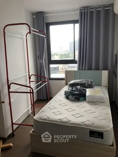 Cozy bedroom with city view, featuring a single bed and modern decor, perfect for urban living.