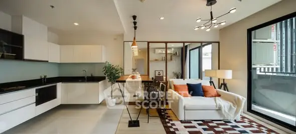 Modern open-plan living room and kitchen with stylish decor and large windows.
