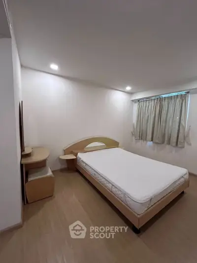 Spacious bedroom with modern furniture and natural light