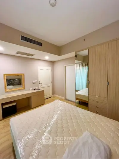 Spacious bedroom with modern furniture and ample storage space