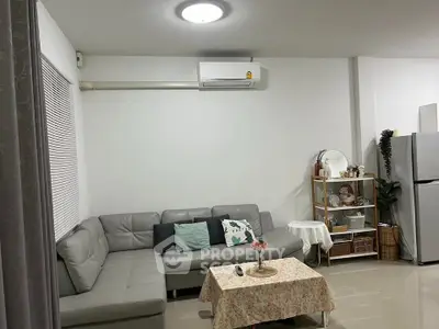 Cozy living room with modern gray sofa and air conditioning, perfect for relaxation.