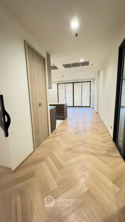 Spacious modern apartment with elegant wooden flooring and large windows for natural light.