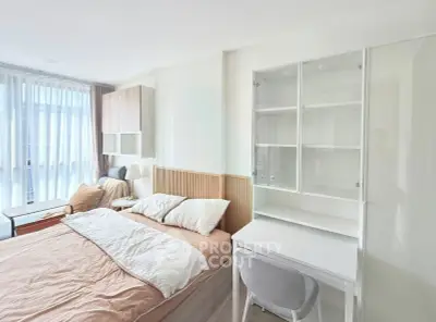 Bright and cozy bedroom with modern furnishings and ample natural light.