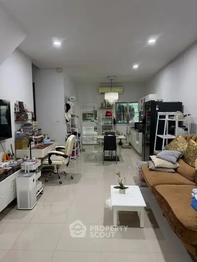 Spacious living room with modern decor and open layout, featuring a cozy seating area and sleek furnishings.