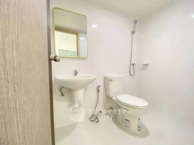 Modern minimalist bathroom with white fixtures and sleek design.