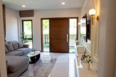 Modern living room with elegant decor and large windows offering natural light.