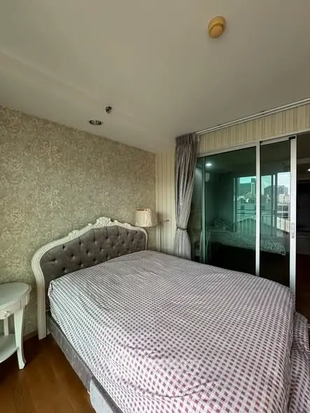 Charming bedroom with elegant decor and city view, featuring a plush bed and stylish wallpaper.