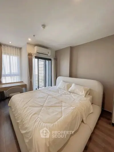 Spacious bedroom with modern design and large windows for natural light.