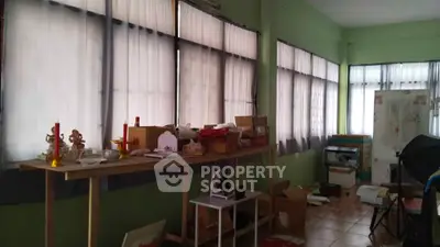 Spacious room with large windows and ample natural light, ideal for creative workspace or storage.