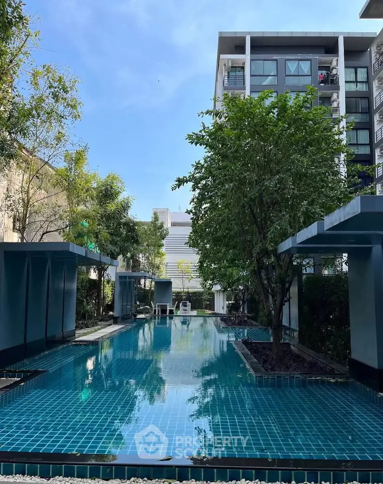 Luxurious condominium with serene outdoor pool and lush greenery, perfect for relaxation and leisure.