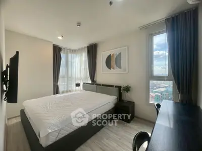 Modern bedroom with large windows and city view, featuring stylish decor and natural light.