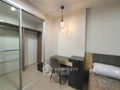 Modern bedroom with sleek desk and built-in closet, perfect for urban living.